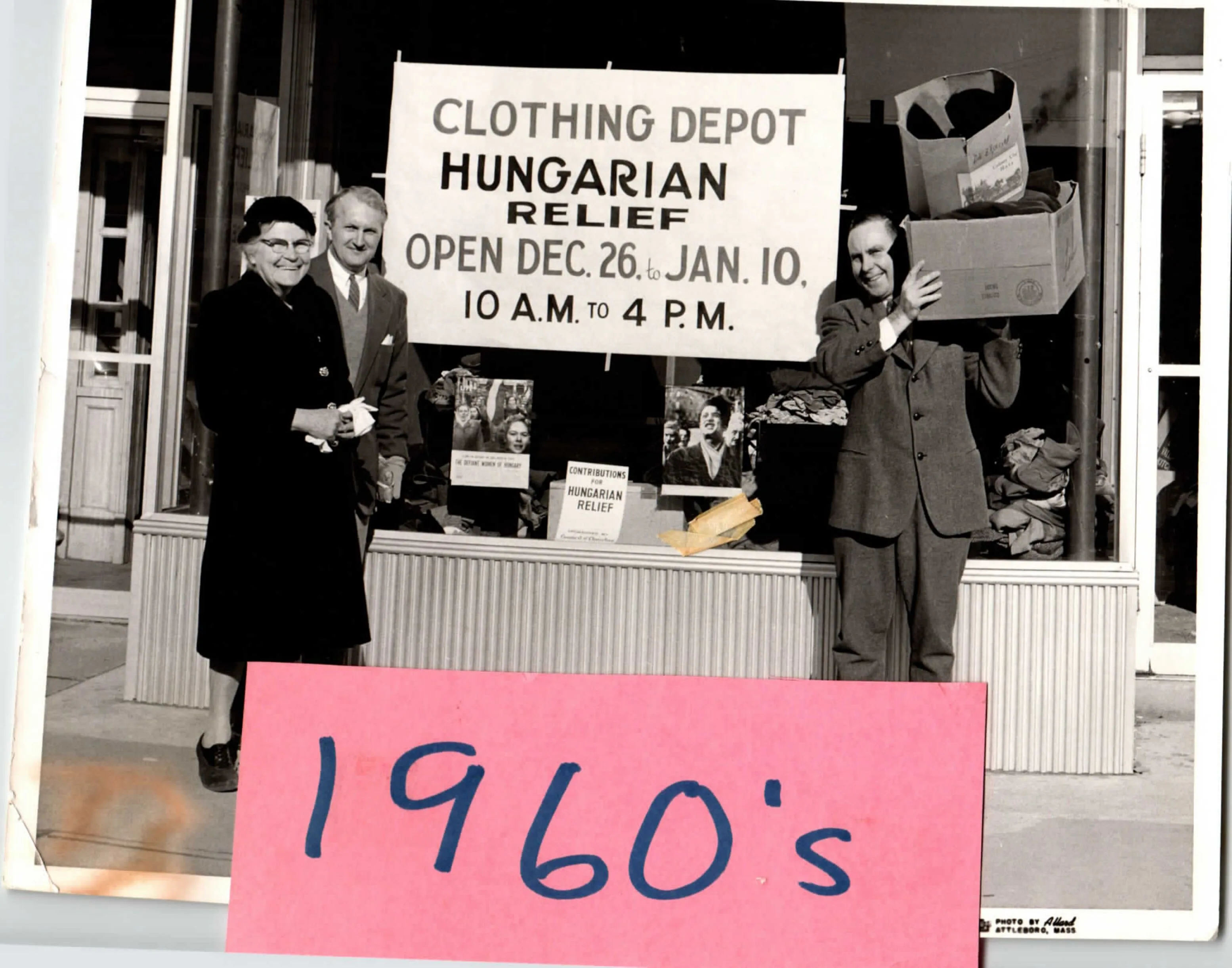 Old archive photo AAIC volunteers with boxes in front of sign reading "CLOTHING DEPOT - HUNGARIAN RELIEF"